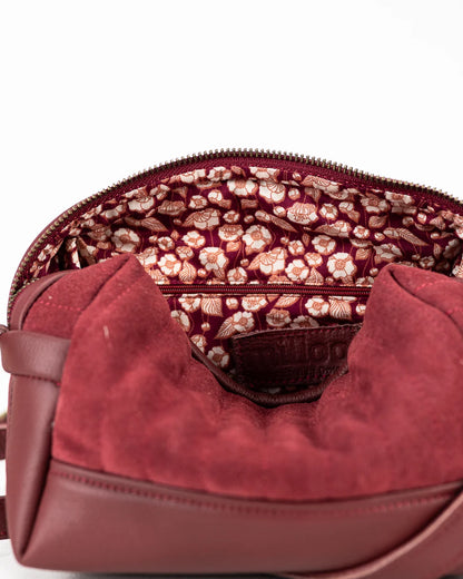 Close-up of a red handbag with floral patterned interior.