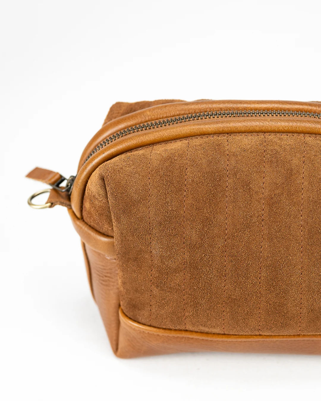 Brown leather toiletry bag with a zipper on a white background