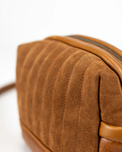 Close-up of a brown leather bag with a zipper on a white background