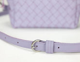 Close-up of a lilac handbag with a matching belt on a white background
