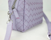 Purple quilted handbag with a strap on a white background