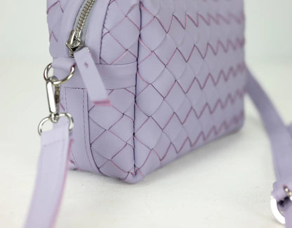 Purple quilted handbag with a strap on a white background