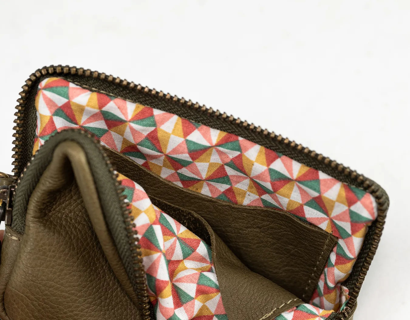 Brown leather wallet with geometric patterned interior on a white background