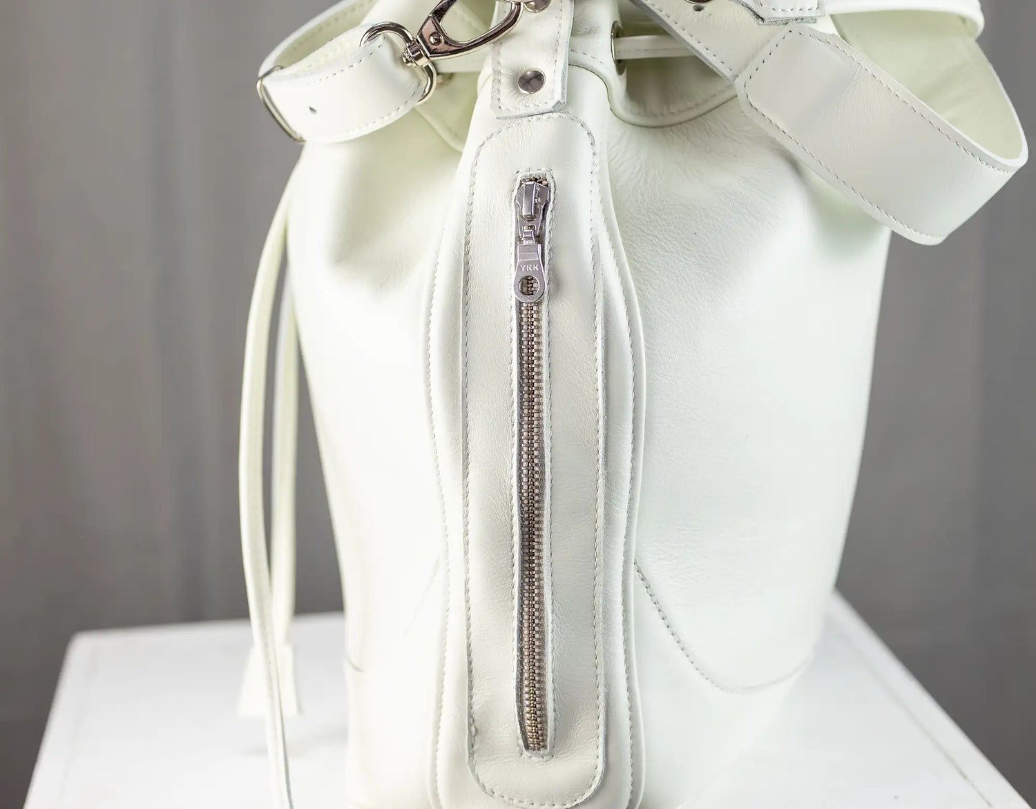 White handbag with a bow on a gray background