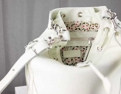 White handbag with floral patterned interior on a gray background