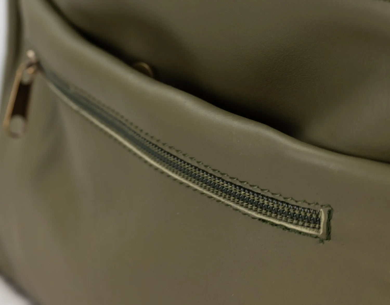Close-up of a green leather bag with a zipper.
