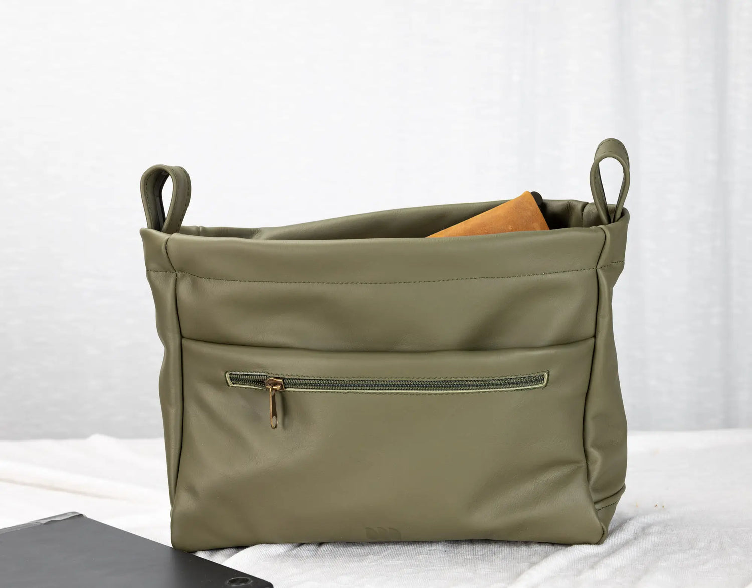 Green bag with a zipper on a white background