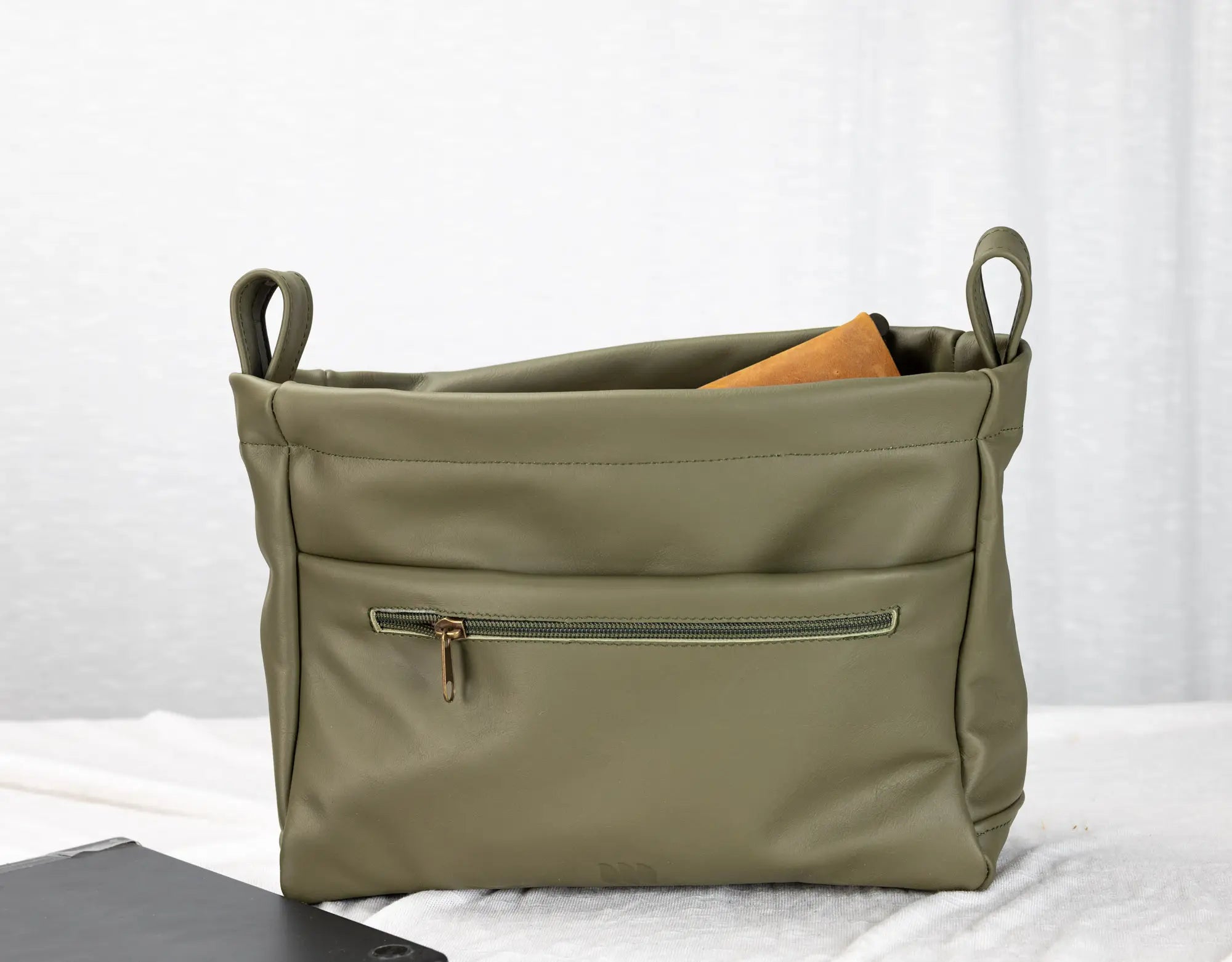 Green bag with a zipper on a white background