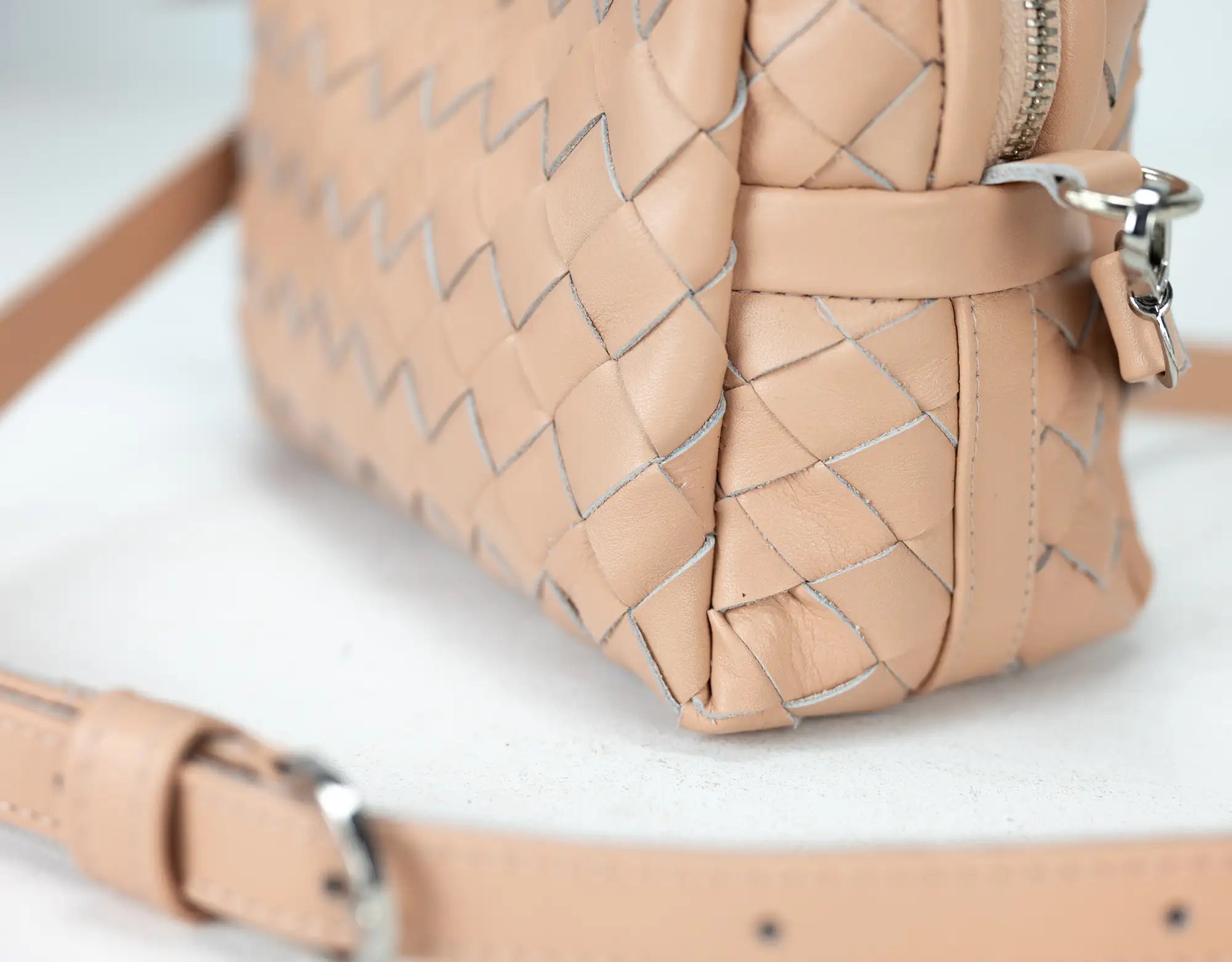 Beige woven handbag on a white background