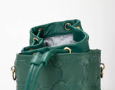 Green leather bucket bag with textured surface on a white background