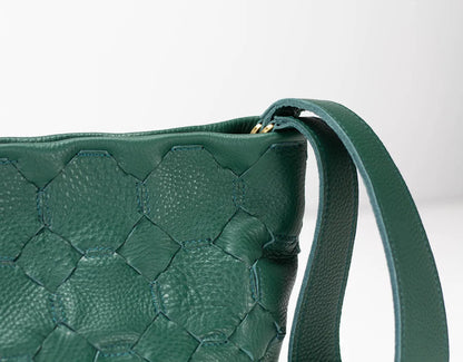 Green woven handbag with a strap on a white background