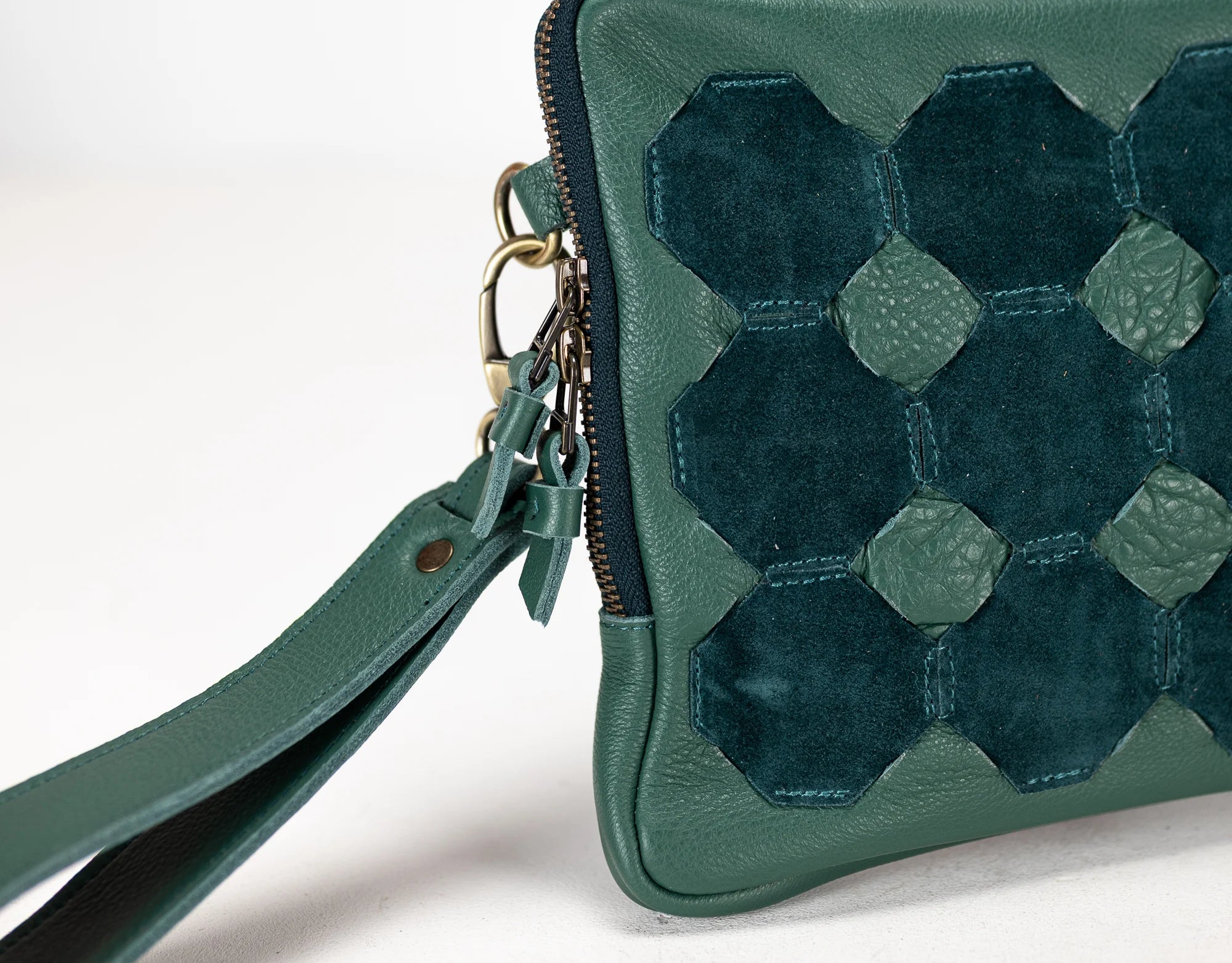 Green handbag with geometric pattern on a white background