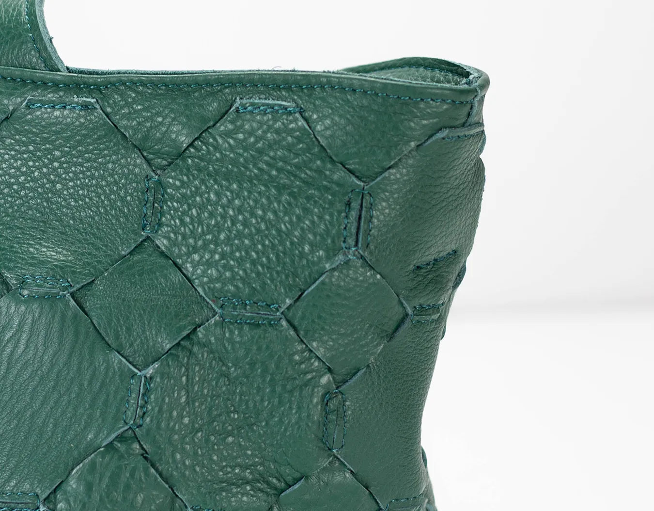 Close-up of a green textured handbag on a white background