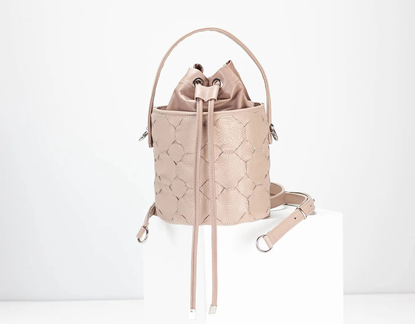 Beige woven bucket bag on a white background