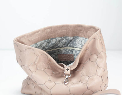 Beige textured handbag with floral lining on a white background