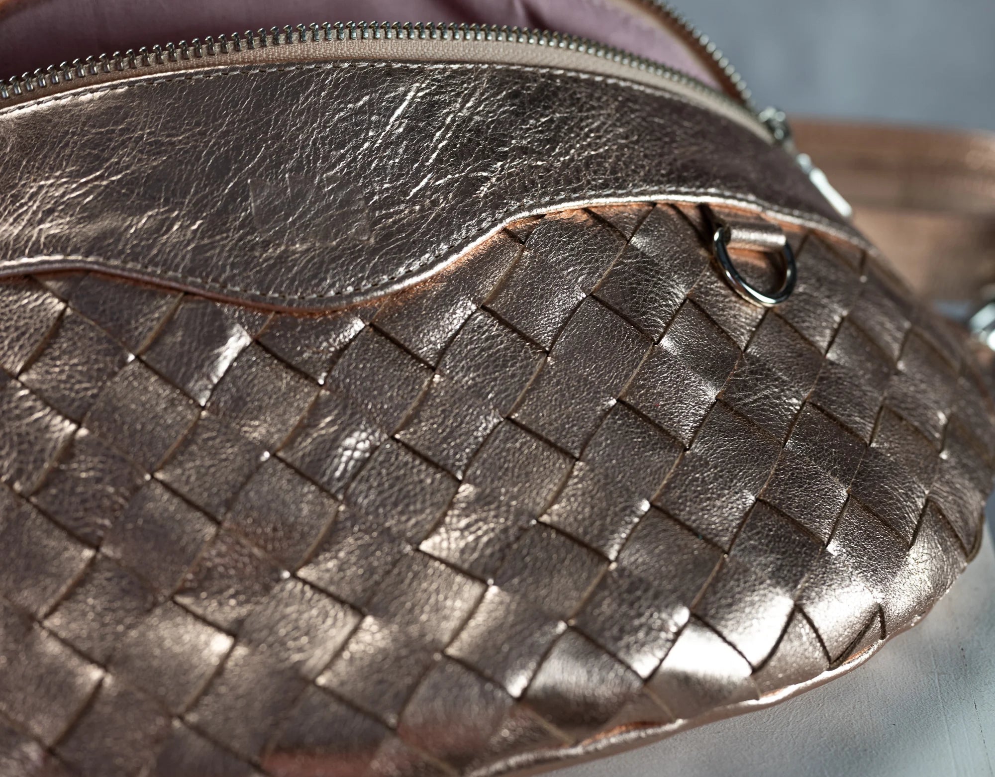 Close-up of a woven leather handbag with a blurred background