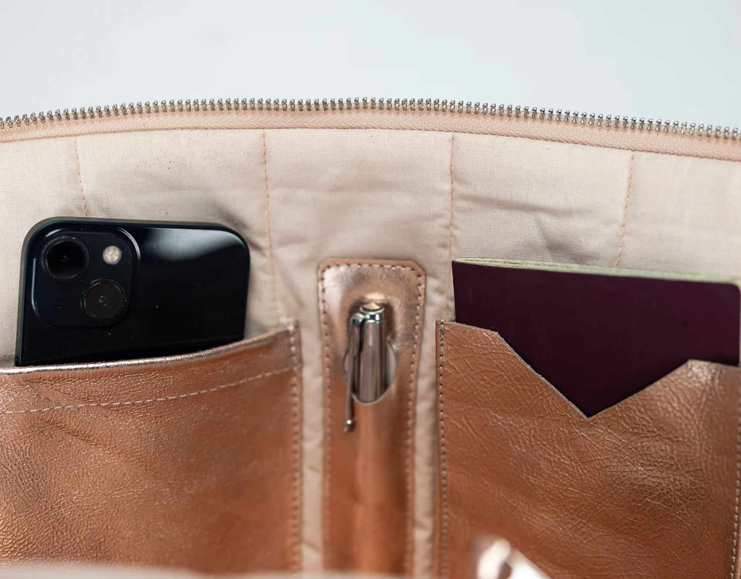 Close-up of a beige leather wallet with a phone and card holder.