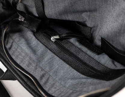 Close-up of the interior of a gray fabric bag with black textured trim and zipper details.