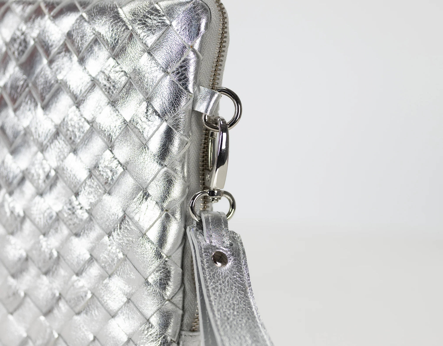 Silver woven clutch bag with a zipper on a white background