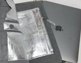 Gray laptop case with a silver laptop inside, showing Apple logo.