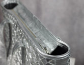 Close-up of a silver clutch with intricate designs 