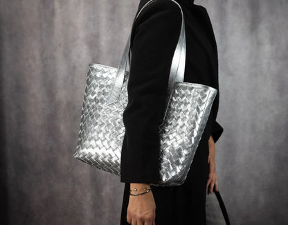 Person holding a silver woven handbag 