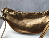 Brass leather handbag with a strap on a light gray background