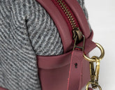 Close-up of a maroon handbag with gold hardware 