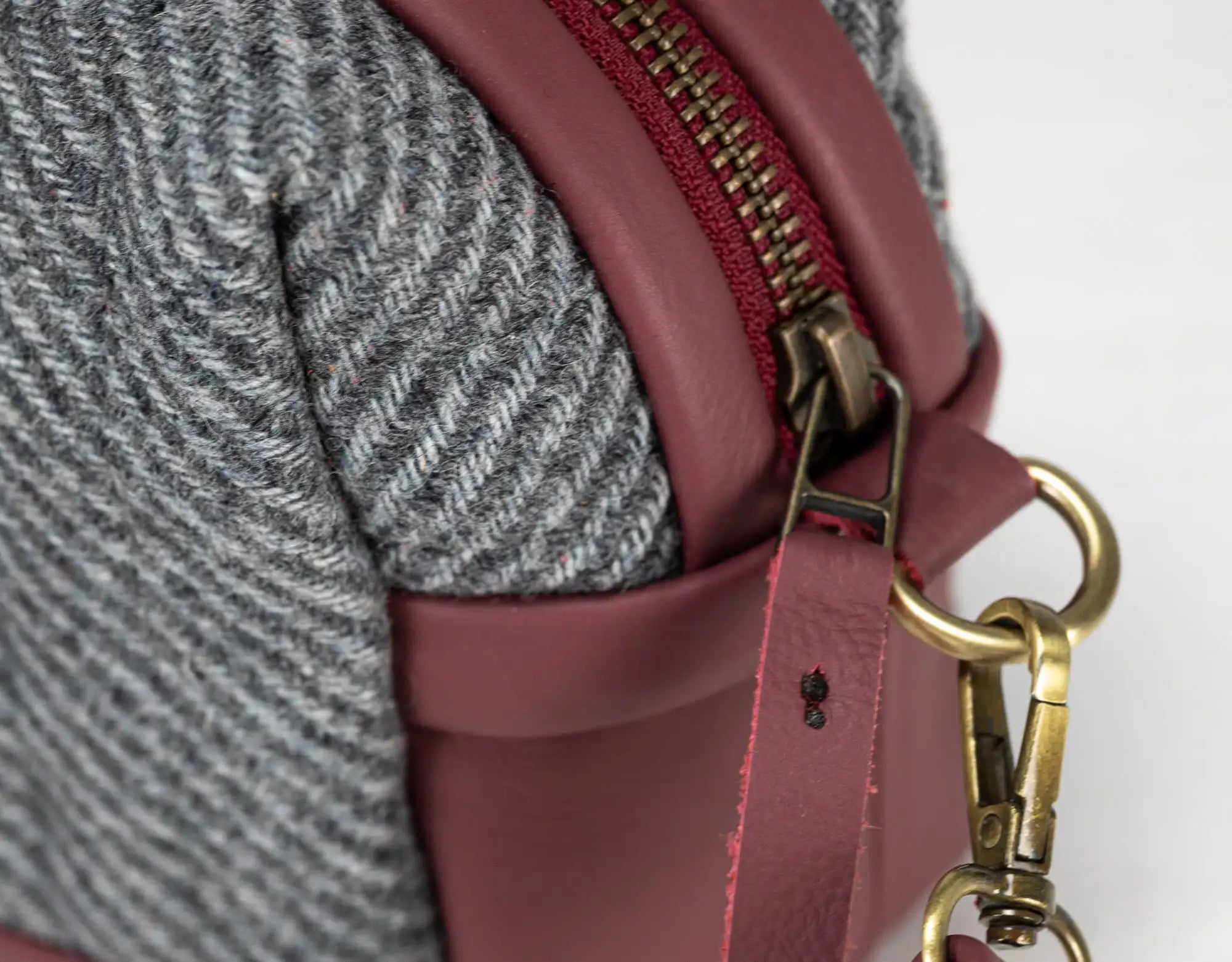Close-up of a maroon handbag with gold hardware 