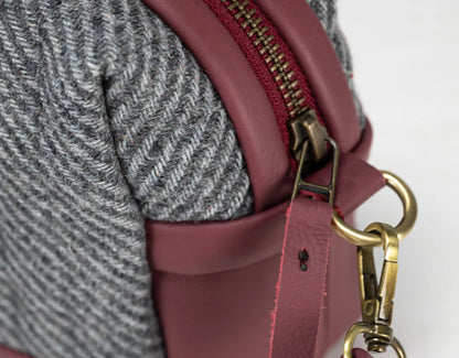 Close-up of a maroon handbag with gold hardware 