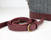 Maroon leather strap with gold buckle on a white background