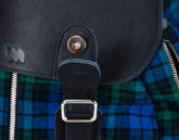 Close-up of a black bag with a plaid pattern, featuring a brand logo.