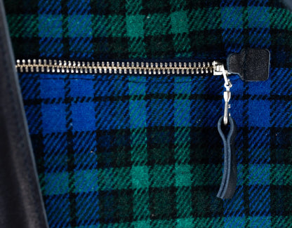 Close-up of a blue and green plaid fabric with a zipper and keychain.