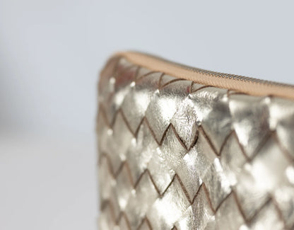 Close-up of a metallic textured clutch bag on a light gray background