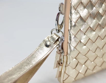 Gold woven handbag with a strap on a light gray background