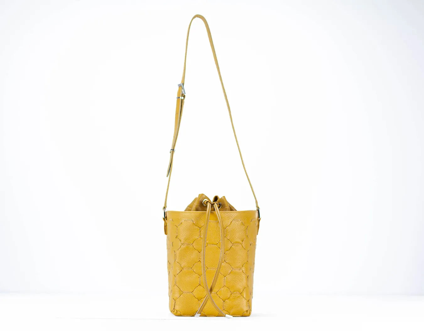 Yellow quilted handbag with a strap on a white background