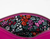 Floral-patterned pouch with pink zipper on a white background