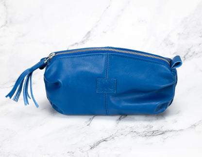 Blue leather pouch with a tassel on a marble surface