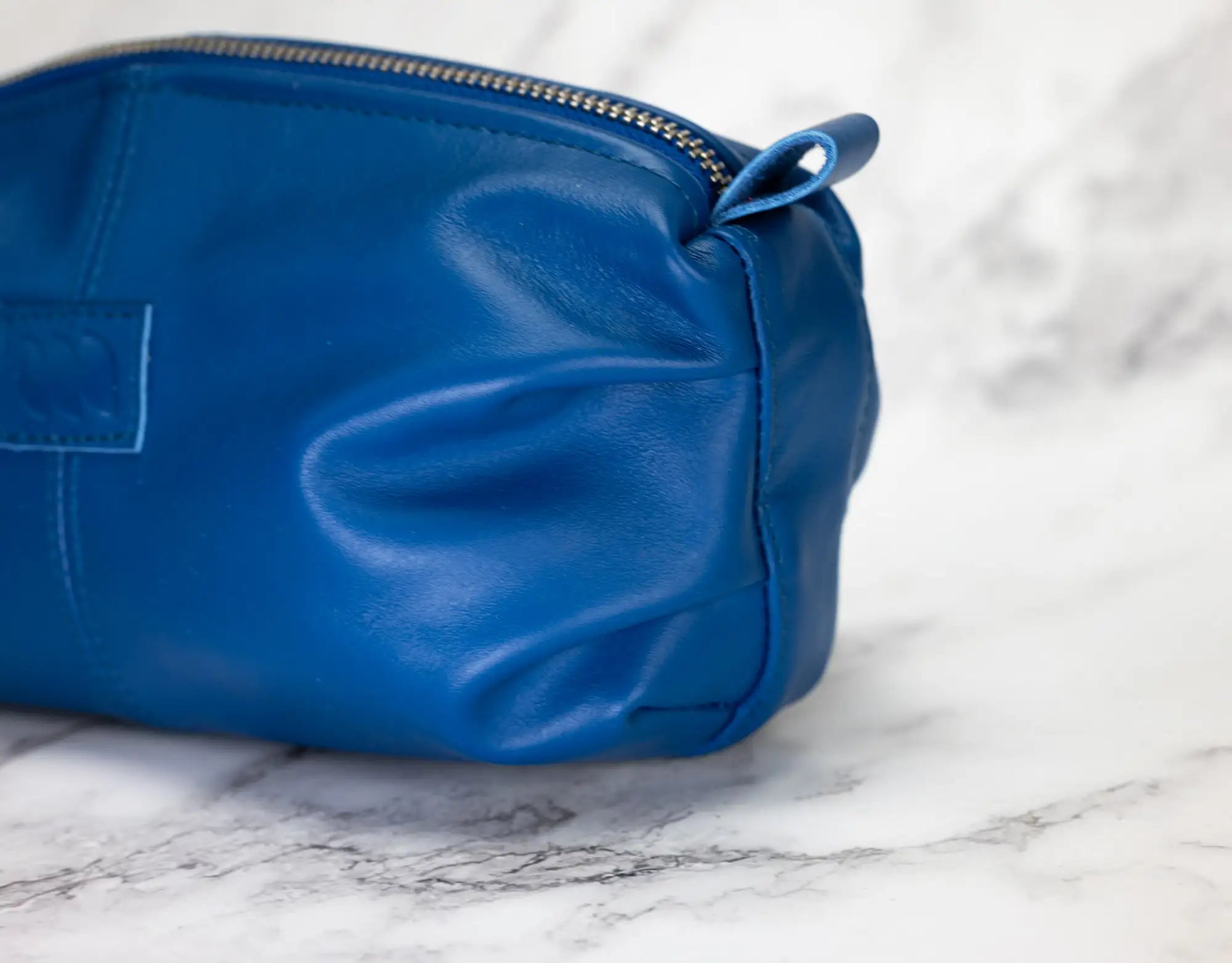 Blue leather pouch on a marble surface
