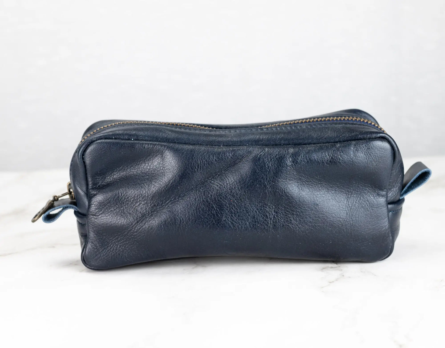 Blue leather toiletry bag on a white background