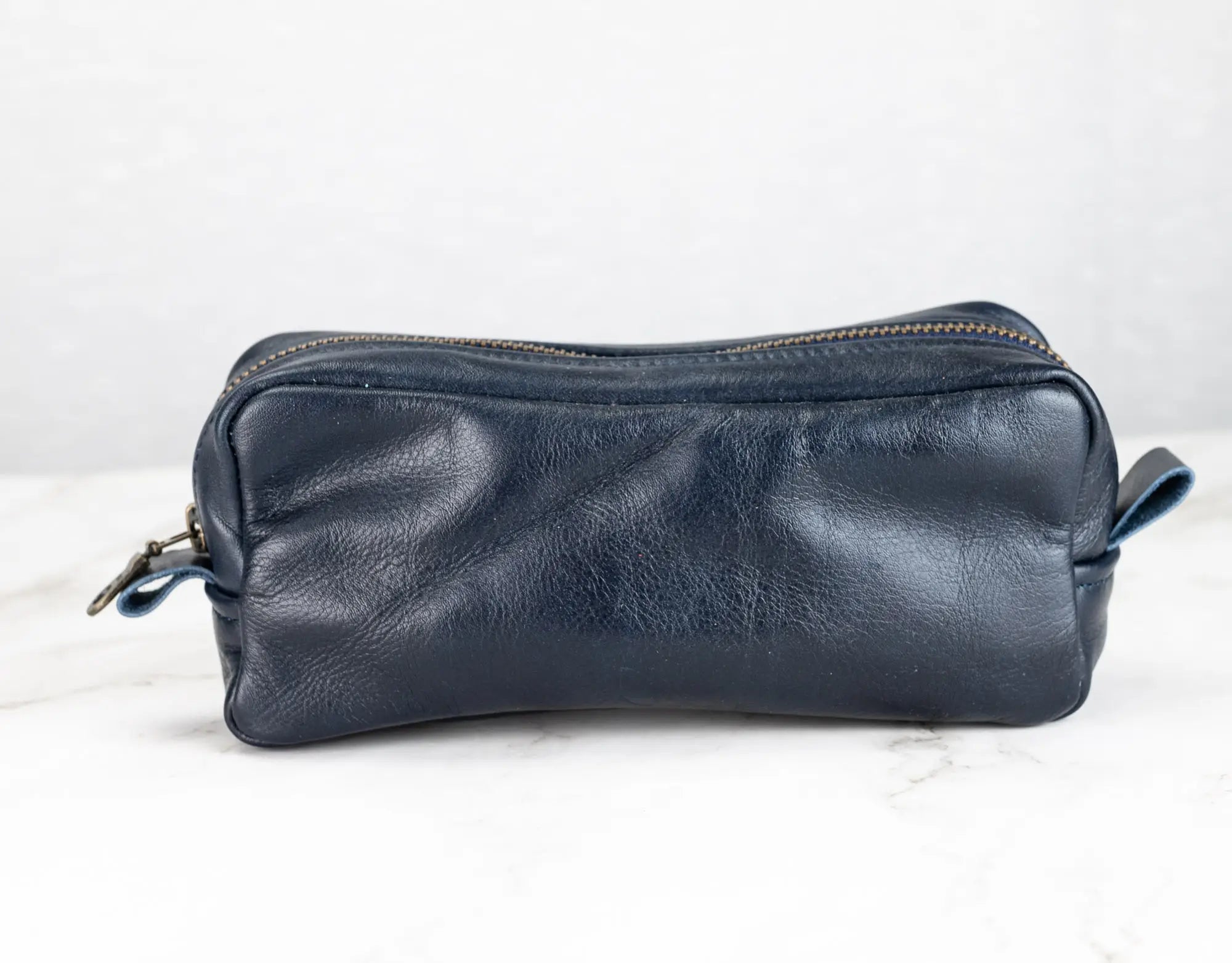 Blue leather toiletry bag on a white background