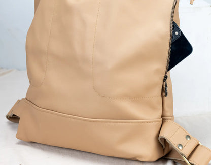 Close-up of a beige leather backpack on a light background