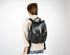 Person wearing a black backpack on a white background