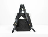 Black backpack with gold buckles on a white background