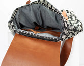 Brown leather bag with patterned flap on a white background