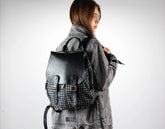 Person wearing a houndstooth pattern backpack with a plain background
