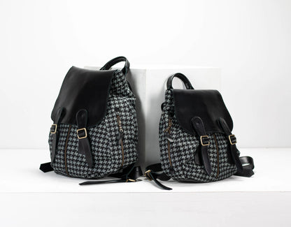 Two backpacks, one with a houndstooth pattern and the other black, on a white background.