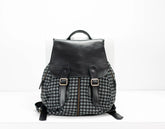 Black and gray checkered backpack with leather straps on a white background