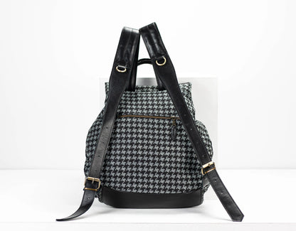 Backpack with houndstooth pattern and black straps on a white background