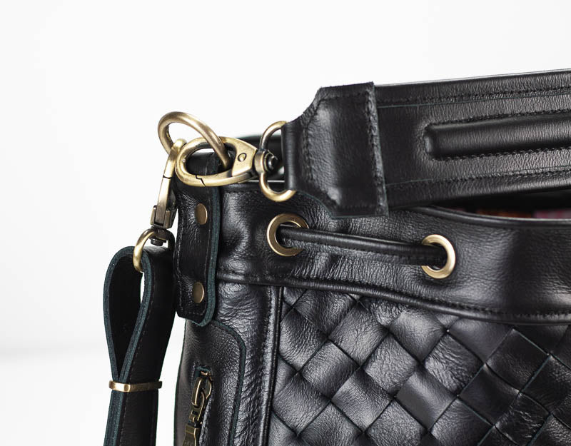 Black quilted leather handbag with gold hardware on a white background